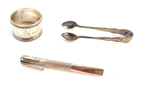 A group of silverware, comprising a George V silver napkin ring, engraved PMS, Birmingham 1925, a set of silver Fiddle pattern sugar nips, Birmingham 1907, and a faceted silver pencil case, makers stamp VI, Birmingham 1925, 2½oz gross. (3)