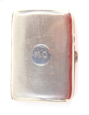 A George VI silver cigarette case, with engine turned decoration and circular crest bearing the initials MG, Birmingham 1945, 2oz.