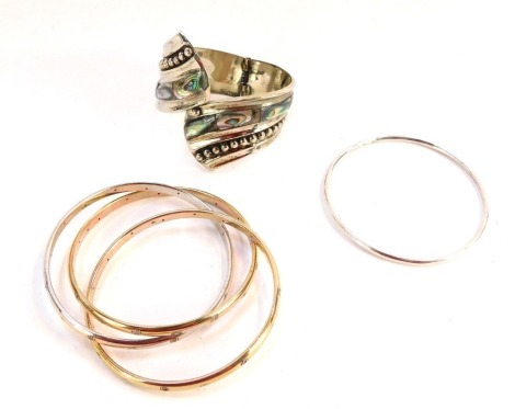 A group of bangles, comprising a thin bangle stamped 925, a mother of pearl inlaid and white metal bangle stamped Mexico 925, and three interlinked bicolour and cz stone set bangles stamped 9k, silver 1½oz gross.