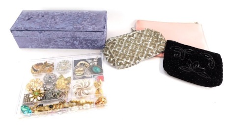 A group of costume jewellery brooches, paste stone set brooches, three evening purses and a purple crushed velvet jewellery box. (a quantity)