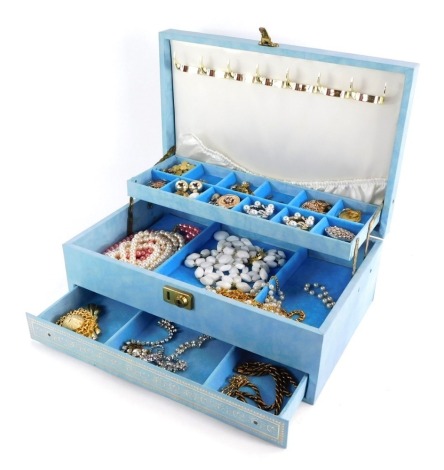 A blue material cantilever jewellery box and contents, comprising brooches, clip-on earrings, tie clips, paste stone set necklaces, etc. (a quantity)