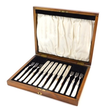 A cased set of six plated and mother of pearl handled knives and forks, in a fitted oak presentation case, with silk lining.