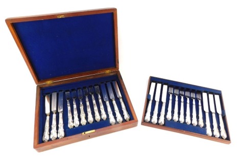 A cased set of twelve silver plated knives and forks, each with a fluted handle with lion crest emblem, in an oak fitted case.