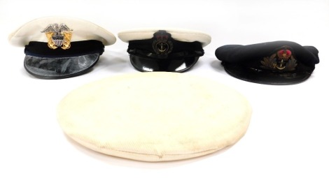 Four Naval caps, comprising a Royal Naval officer's peaked cap, a US Navy Officer's peaked cap, a sailors white cap, and a WWII Royal Navy officer's cap. (4)