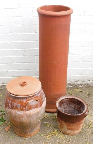 A terracotta chimney pot, and two brown glazed stoneware planters. (3)