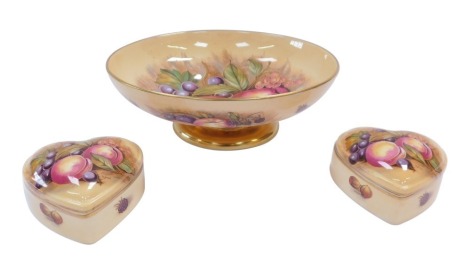 A group of Aynsley Fruits and Flowers pattern wares, comprising a fruit bowl, 25cm diameter and two trinket jars in the form of hearts, 8cm wide. (3)