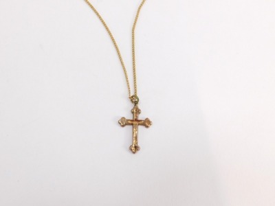 A crucifix pendant and chain, the crucifix with floral scroll decoration and single loop top, on a fine link chain, stamped 9ct, the crucifix 2.5cm high, the chain 40cm long, 2.6g all in. - 2