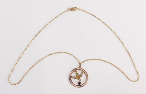 An Edwardian pendant and chain, the circular swallow pendant set with seed pearls with a garnet set drop, 3cm diameter, yellow metal unmarked, on a fancy link neck chain, yellow metal stamped 375 to clasp, 42cm long overall, 4.6g all in, in a Goldsmiths &