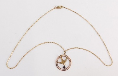 An Edwardian pendant and chain, the circular swallow pendant set with seed pearls with a garnet set drop, 3cm diameter, yellow metal unmarked, on a fancy link neck chain, yellow metal stamped 375 to clasp, 42cm long overall, 4.6g all in, in a Goldsmiths &