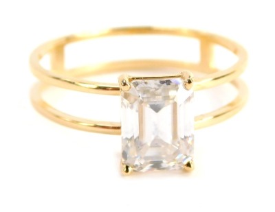 A single stone moissanite dress ring, the rectangular cut and faceted moissanite with four claw basket setting on two splayed band, yellow metal stamped 18k, ring size R½, boxed.