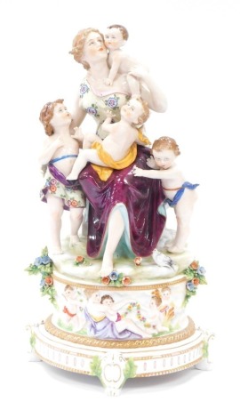 A Capodimonte porcelain figure group of mother and four children, on a circular foot, with four scroll feet, 41cm high.