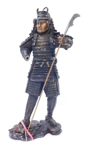 A bronze figure of a warrior, in Eastern design, with layered armour and weapon, 43cm high. (AF)