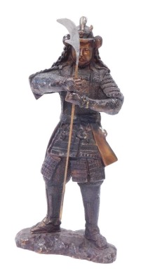 A bronze figure of a warrior, in Eastern design, with layered armour and weapon, 43cm high.