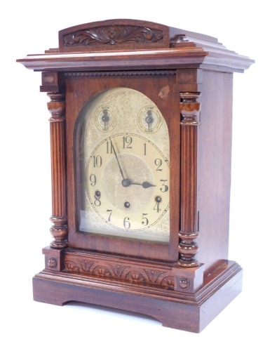 An early 20thC oak cased mantel clock, with arched pediment top and two column support, with a brass dial with Westminster chiming movement, 42cm high, 28cm wide, 21cm deep.