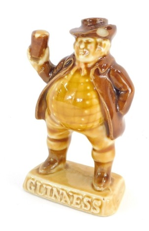 A Guinness advertising figure, in brown treacle glaze, on a square base, 8cm high.