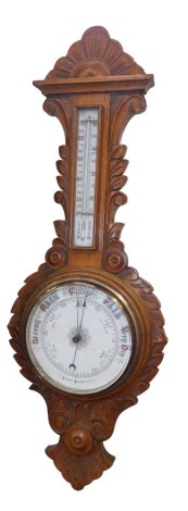 A 19thC oak aneroid barometer, the shell carved and leaf border, with white enamelled dials, 81cm high, 31cm wide.