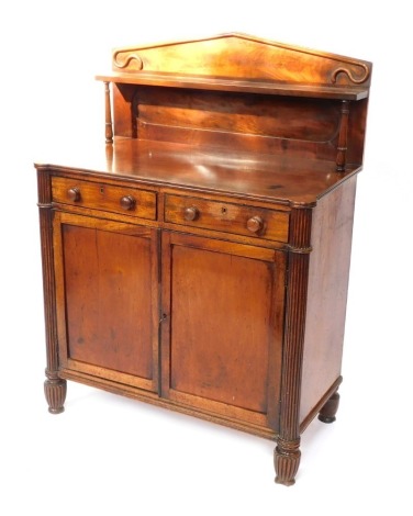 A late Regency mahogany chiffonier, the pedimented back with a single shelf raised on turned columns, over two drawers above a pair of panelled doors, raised on fluted columns and feet, 123cm high, 91cm wide, 48cm deep.