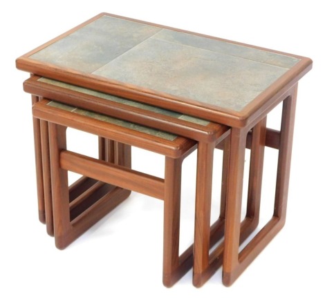 A nest of three teak and tile topped tables, the largest table 40cm high, 54cm wide, 34cm deep.