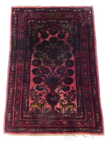 A Persian type silk rug, with central pink floral panel with two deers and urn of flowers, with three flowered border, with type weave reverse, 74cm x 65cm.