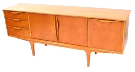 A 1970's teak sideboard, with three cupboard doors and three drawers, with moulded handles on square tapered legs, 73cm high, 182cm wide, 44cm deep.