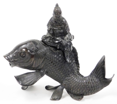 A Japanese Meiji period bronze vessel and cover, shaped as the figure of Kinko holding a book or scroll (now missing) riding a carp, 19cm high.