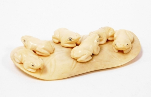 A 19thC Oriental ivory carving of six frogs on a lilypad, 10cm wide.