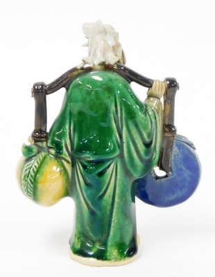 A Chinese pottery figure of a sage, carrying yoke bearing a coin and a flowering peach, 15cm high, and two porcelain figural snuff bottles, 9cm and 8cm high. - 10