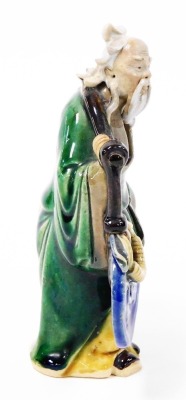 A Chinese pottery figure of a sage, carrying yoke bearing a coin and a flowering peach, 15cm high, and two porcelain figural snuff bottles, 9cm and 8cm high. - 11