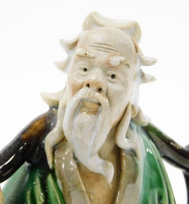 A Chinese pottery figure of a sage, carrying yoke bearing a coin and a flowering peach, 15cm high, and two porcelain figural snuff bottles, 9cm and 8cm high. - 12