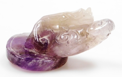 A Chinese amethyst paperweight carved in the form of a lizard, four character mark to the underside, 10cm wide.