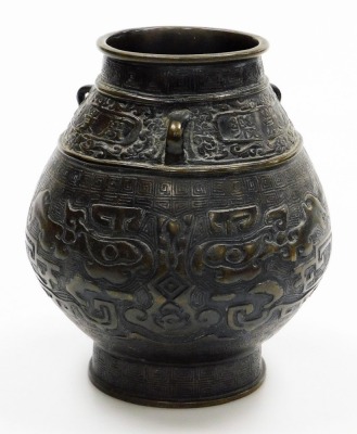 A bulbous Chinese bronze vase, on flared foot, the body cast with archaistic reliefs of animals below lug handles and frieze with inscription, the base with six character mark, 19cm high.