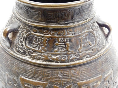 A bulbous Chinese bronze vase, on flared foot, the body cast with archaistic reliefs of animals below lug handles and frieze with inscription, the base with six character mark, 19cm high. - 7