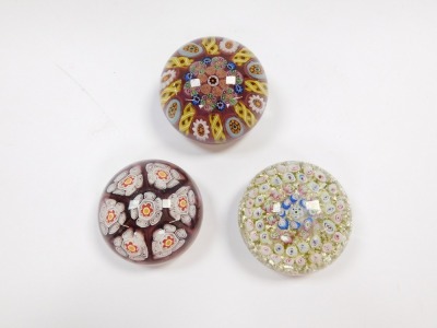 A millefiori and banded latticino glass paperweight, 8cm diameter, paperweight with seven large millefiori floral canes, 7cm diameter, and a concentric millefiori paperweight, with a pale green and silver ground, 7.5cm diameter. (3) - 4