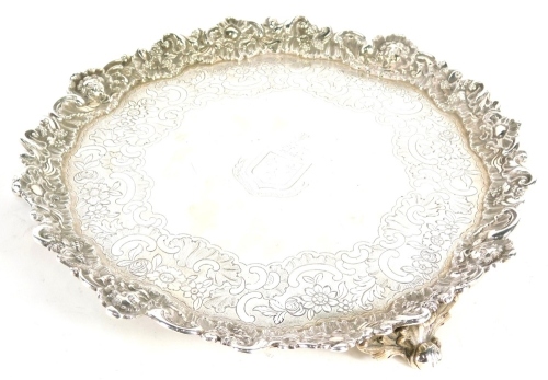 A George IV Scottish silver salver, with pie crust edge, etched central crest, outer engraved scroll work, on triple scroll and floral feet, Edinburgh 1829, 31oz.