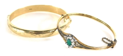 A 9ct gold bangle, partially chased, 6cm wide, possibly filled, 12g all in, and a further Art Deco bangle set with paste and emerald coloured stone. (2)