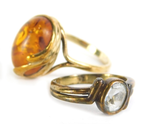 A dress ring, set with oval section of amber in part pierced shank, marked 375, size R, 3g, and a further dress ring. (2)