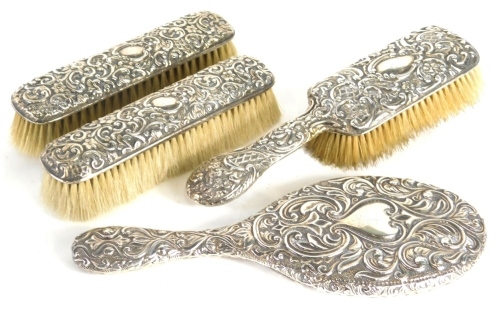 A matched George V four piece silver backed dressing table set, comprising clothes brush, 17cm, by Birmingham 1926, another similar, hand mirror and hair brush. (4)