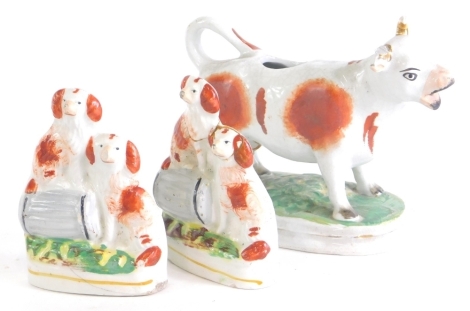 A pair of 19thC Staffordshire flat back spaniel groups, 10cm high, and a cow creamer. (AF)