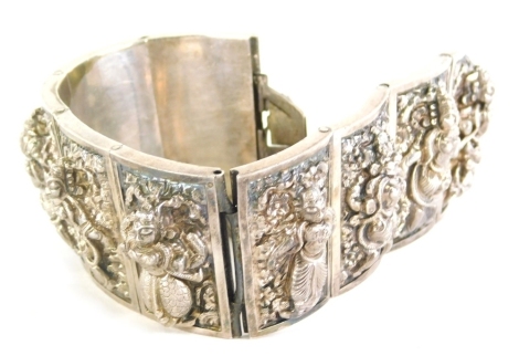 An Eastern inspired bracelet, of graduated form, with nine rectangular panels, each depicting a goddess, white metal, unmarked, with safety chain, 77.2g all in.