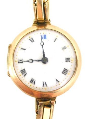 A 9ct gold cased wristwatch, with white enamel dial with Roman numerals, black hands and gold pointers, with a twenty one jewel movement, on an expanding gold plated strap, 19.7g all in. (AF)