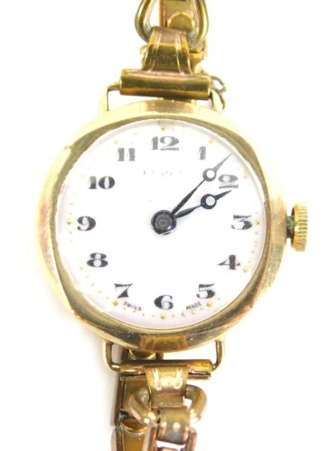 An early 20hC 9ct gold cased ladies wristwatch, with white enamel numeric dial, with gold markers, 2cm wide, on an expanding gold plated strap, with safety chain, 20.8g all in, boxed.