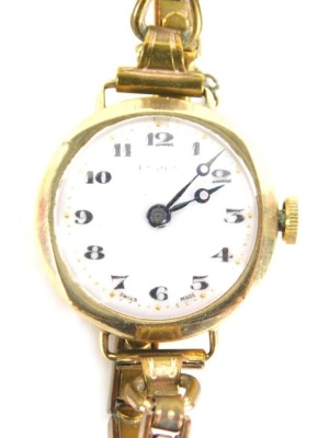 An early 20hC 9ct gold cased ladies wristwatch, with white enamel numeric dial, with gold markers, 2cm wide, on an expanding gold plated strap, with safety chain, 20.8g all in, boxed.