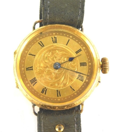 A 18ct gold wristwatch, the circular watch head with Roman numeric dial and scroll design border, with blue hands, in floral scroll casing, on a black leather strap, 35.4g all in.