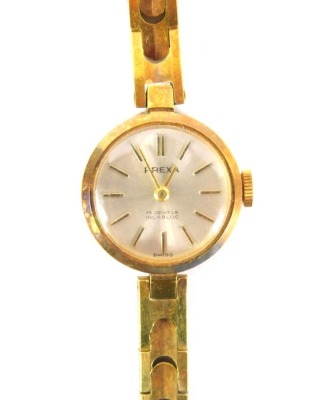 A Prexa ladies wristwatch, on a gold plated strap with silver coloured dial and additional expanding plated strap, boxed.