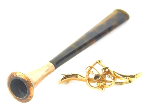 A 9ct gold bar brooch, with heat central motif, on steel back, 5cm wide, and a 9ct gold tipped cheroot holder, on tortoiseshell stem, boxed. (2)