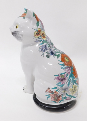 A 20thC Fornasetti pottery figure of a seated cat, partially florally printed, marks beneath, 38cm high.