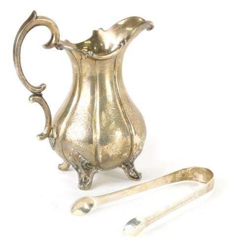 A Victorian silver milk jug, with scroll lip, with a scroll handle, bulbous body partially chased with scrolls and flowers, on quadruple feet, London third letter rubbed, 16cm high, and a pair of silver sugar bows, 9½oz all in. (2)