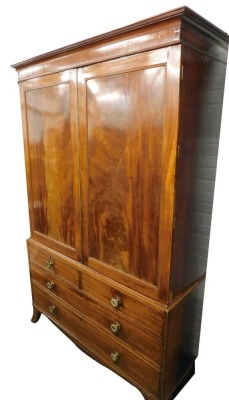 A George III mahogany clothes press, the top with a moulded cornice above two panelled doors enclosing fittings for a hanging rail, the base with two short and two long drawers, each with brass handles, on splayed feet, the top section adapted, 111cm high