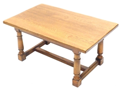 An oak coffee table, the rectangular top on turned supports with H stretcher, 47cm high, the top 60cm x 99cm.