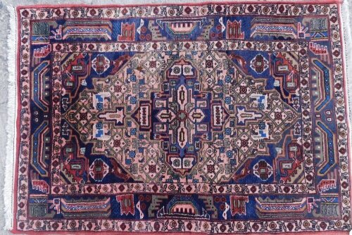 A Persian Kayam rug, with a central four sided shaped medallion, on a blue ground with pink and blue ground, one wide, two narrow borders, 147cm x 103cm.